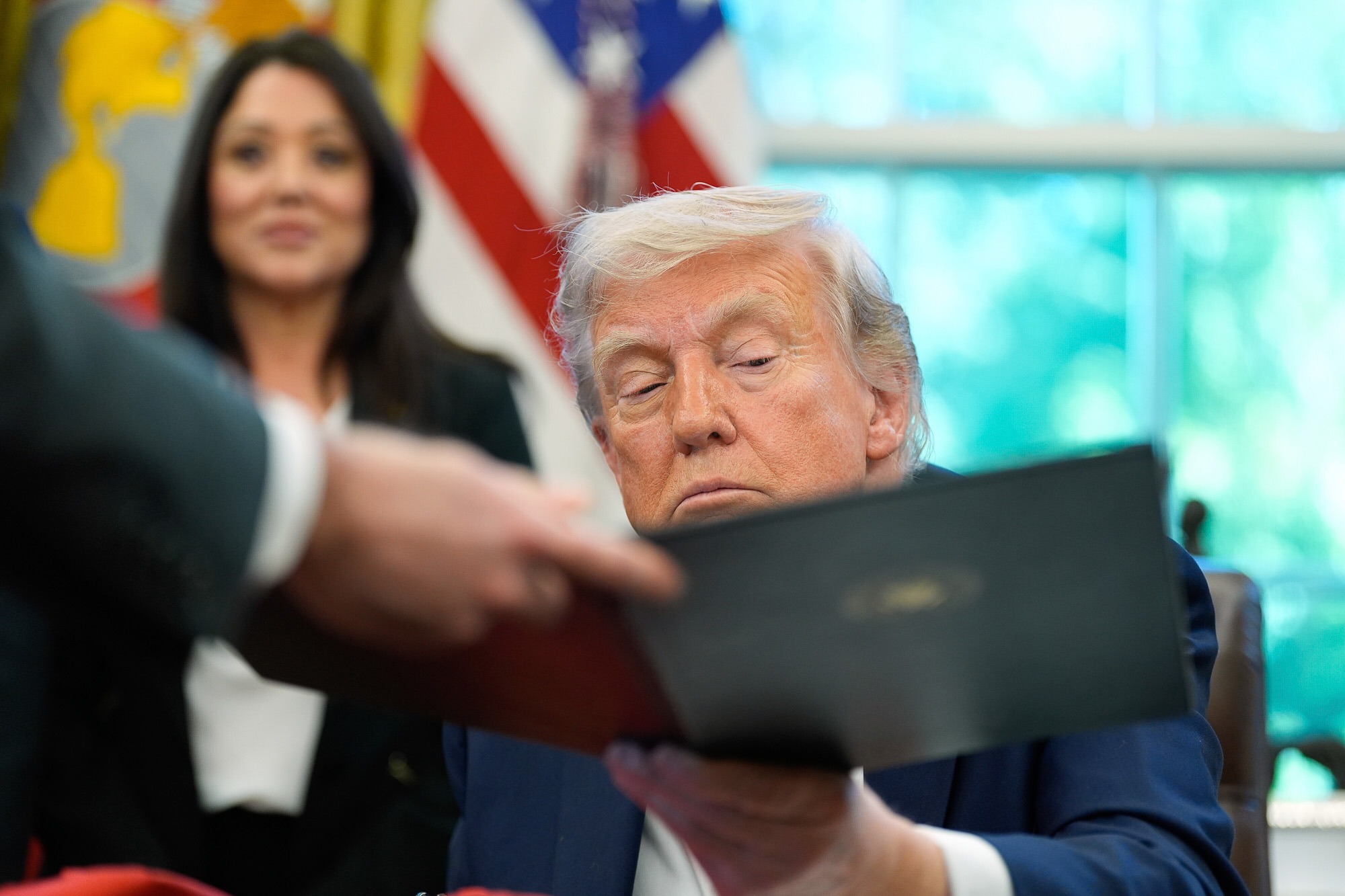 President Donald Trump reviews an executive order at the White House, amid sweeping changes targeting education and civil rights policies.