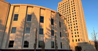Sunlight illuminates the exterior of the North Dakota House of Representatives and the state Capitol tower in Bismarck, N.D.