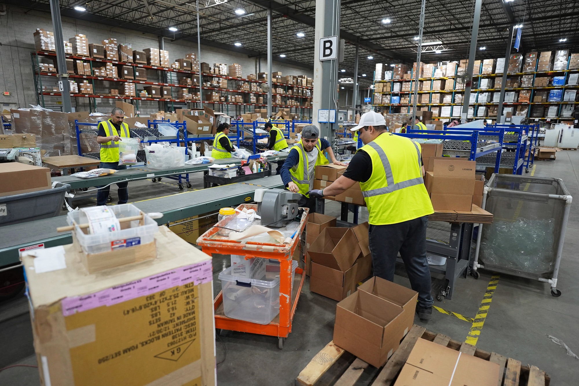 Trump economy faces racial disparities in jobs and wages as warehouse workers pack boxes in 2025.