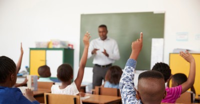 Kids raising hands during a lesson at an elementary school